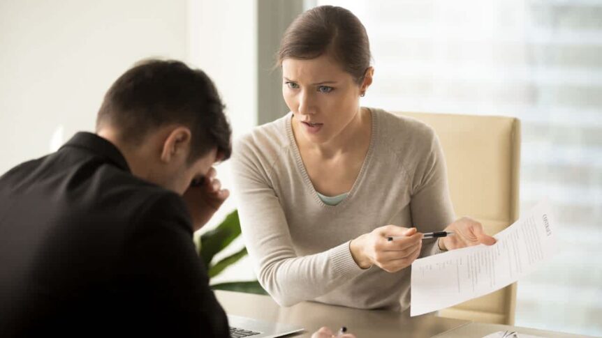 Mulher pressionando um homem durante uma negociação contratual, sugerindo coação e tensão no processo decisório.